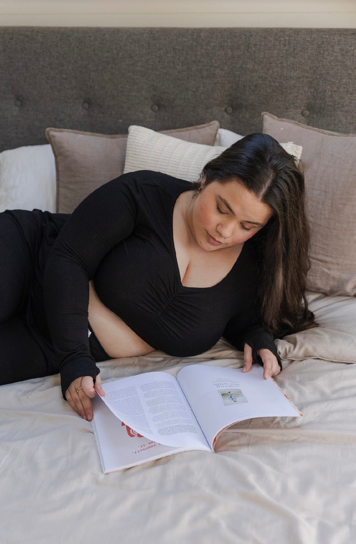 Women wearing a bamboo long sleeve cropped pyjama top in black reading a book