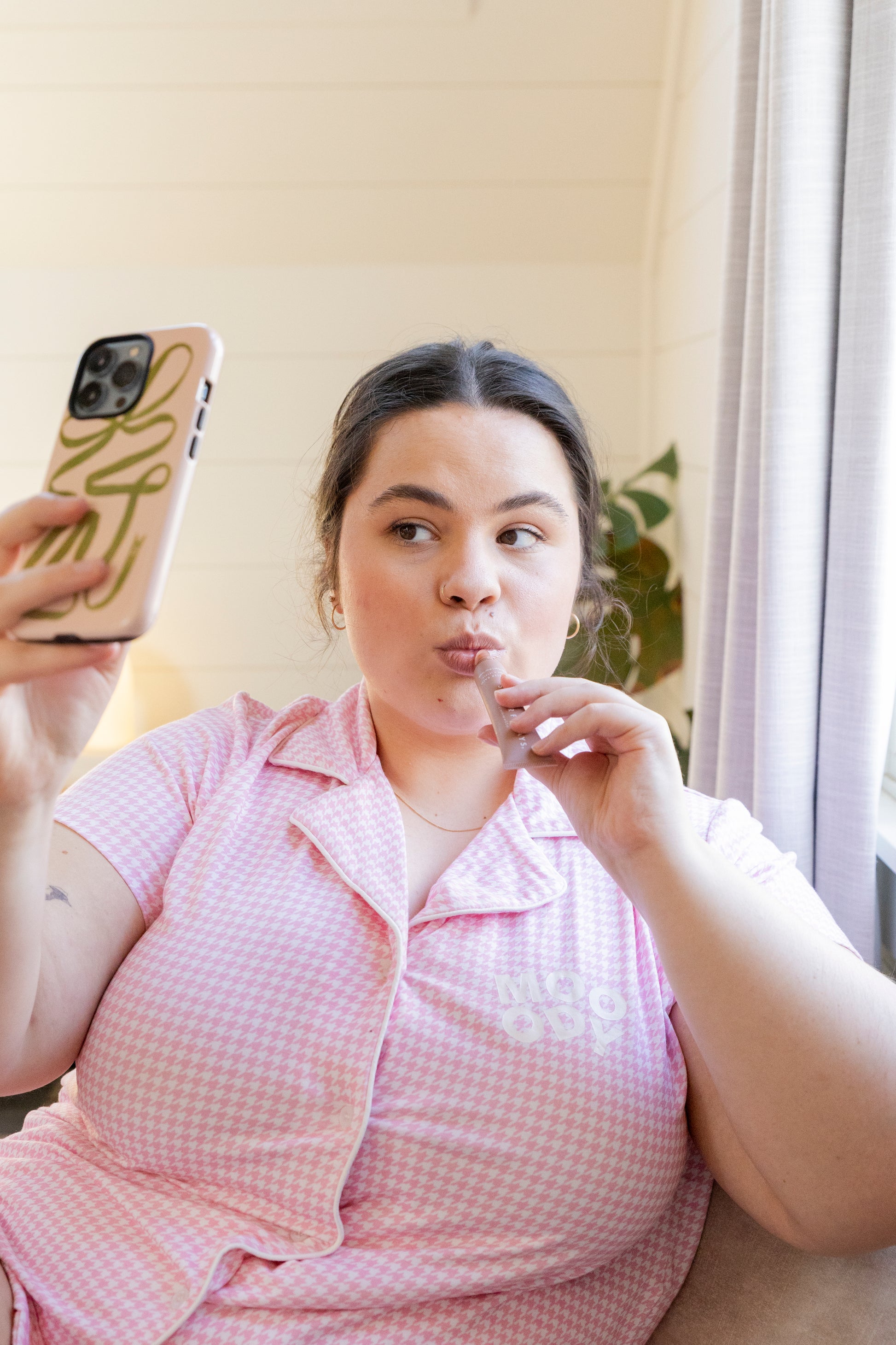 Women wearing Mooody bamboo loose fitted pyjama top short sleeve button up in pink and white houndstooth 